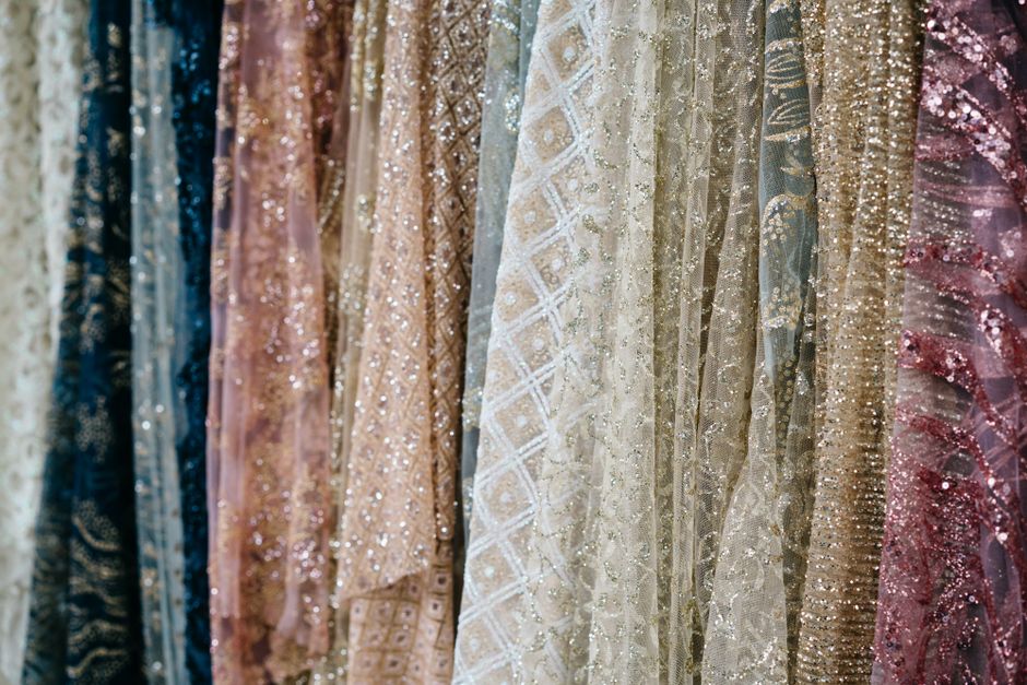 Close-up view of luxurious fabrics with intricate textures and shimmering details, ideal for fashion and design concepts.