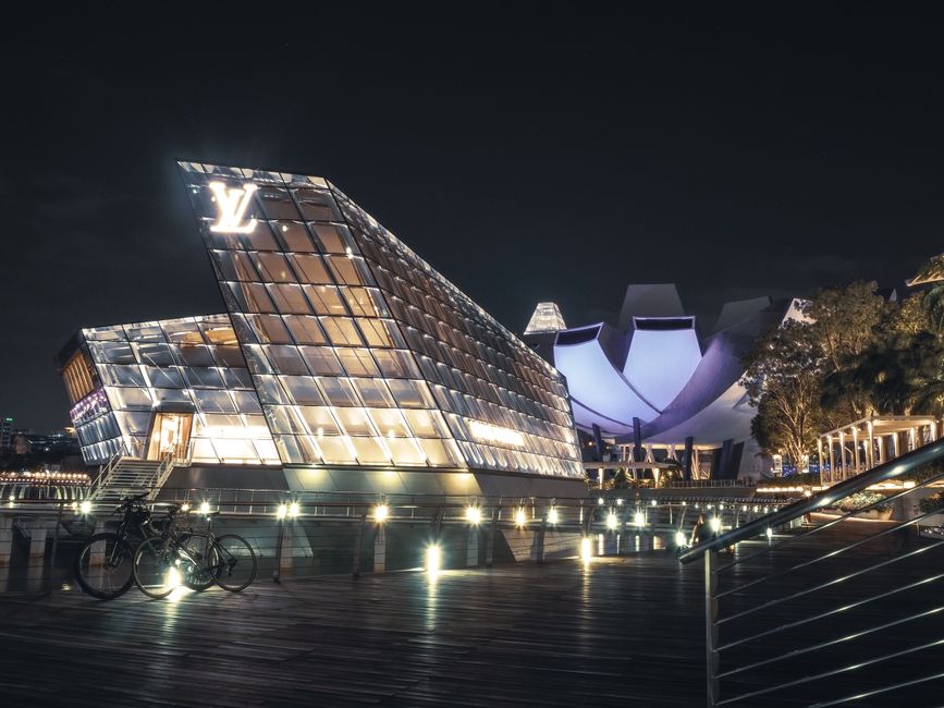 Experience the stunning night view of the iconic Louis Vuitton Island Maison in Singapore, showcasing its modern and luxurious architecture.